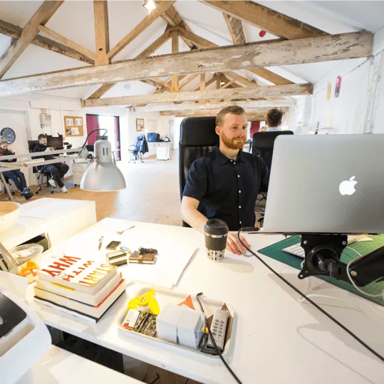 A designer at his desk in a bright studio